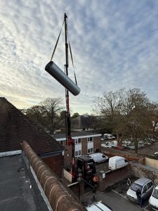 HVAC unit lifted by crane during b2b commercial maintenance installation.