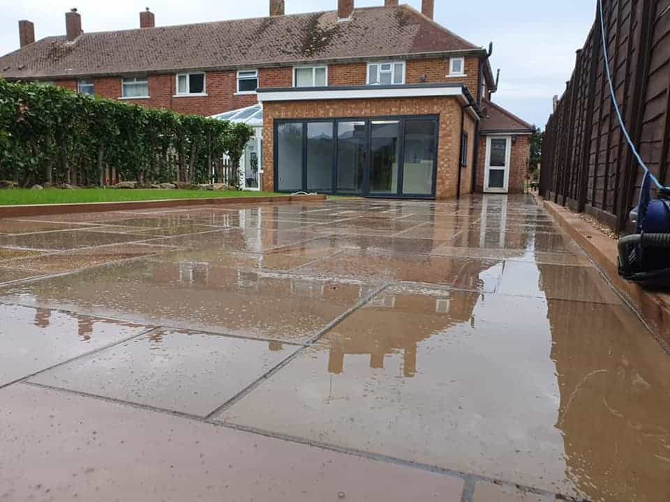 Modern brick home extension with wet concrete patio flooring