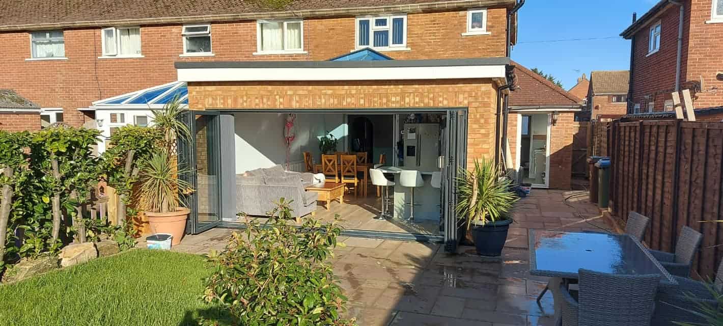 Modern brick house extension with large grey aluminium windows and doors