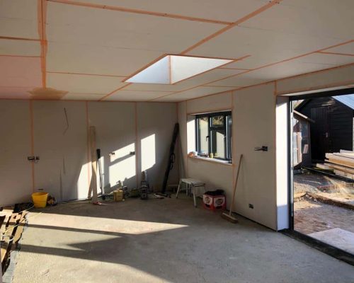Interior construction site with framed walls and skylight opening